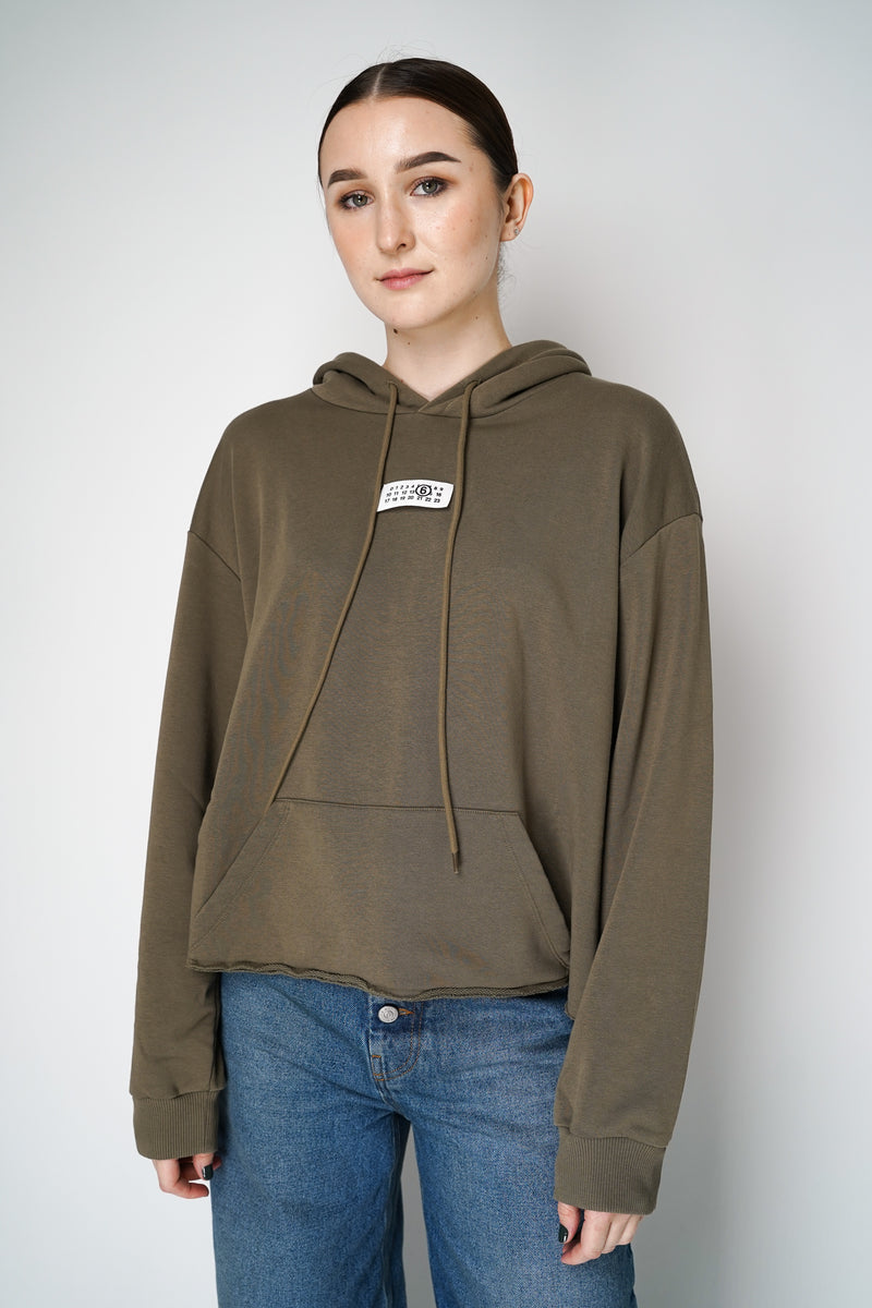 MM6 Signature Logo Hooded Pullover in Bus Green Vancouver. Shop Online or in Store. 